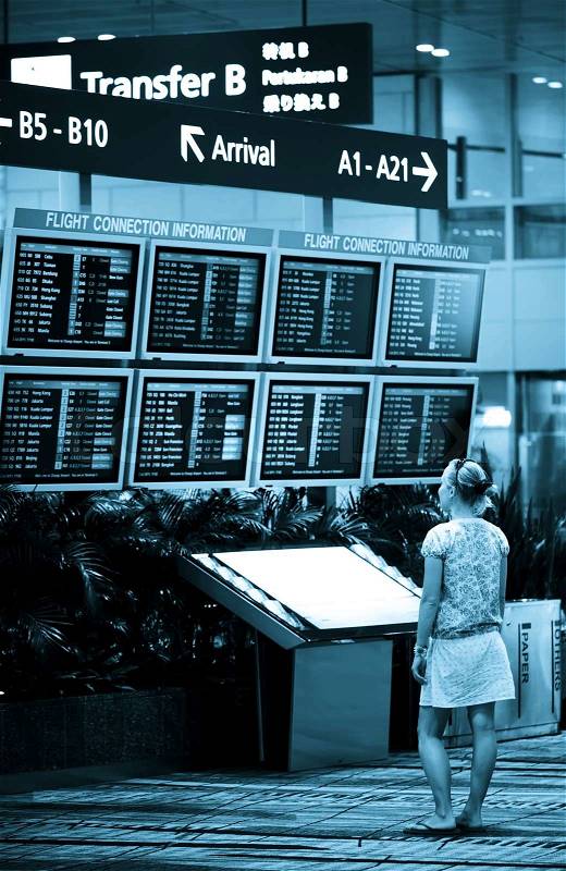 Woman looking on information table at the airport, stock photo