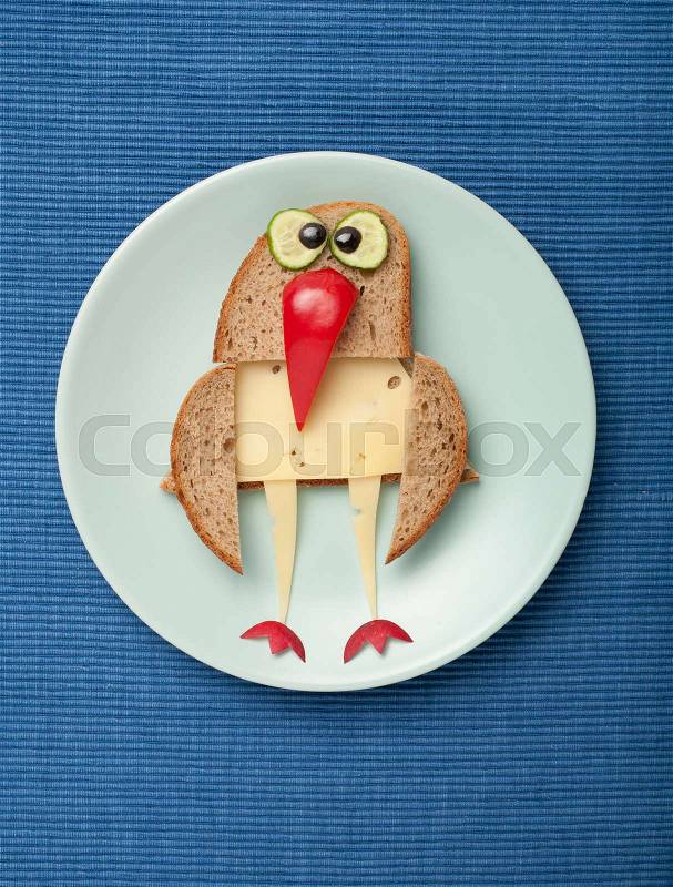 Bird made of bread and cheese on plate and fabric, stock photo