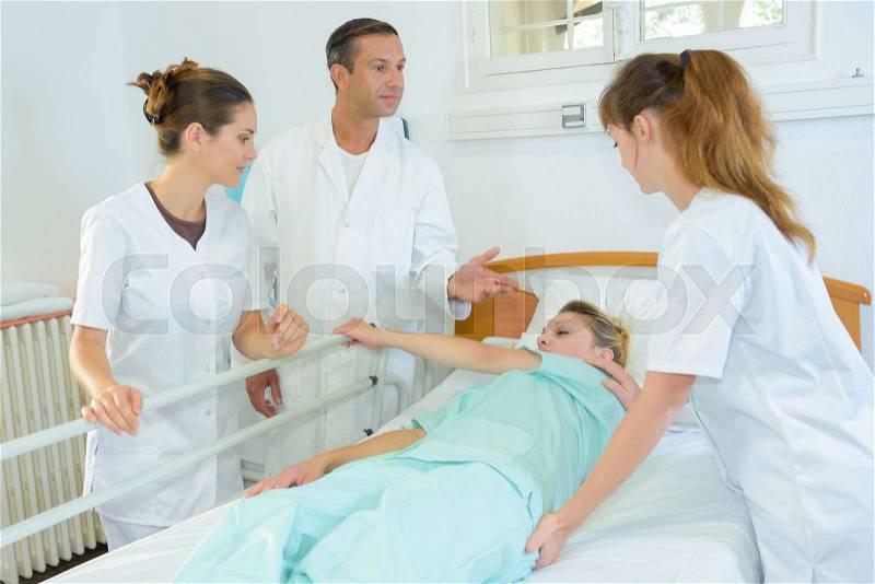 Medical students learning how to turn a patient, stock photo