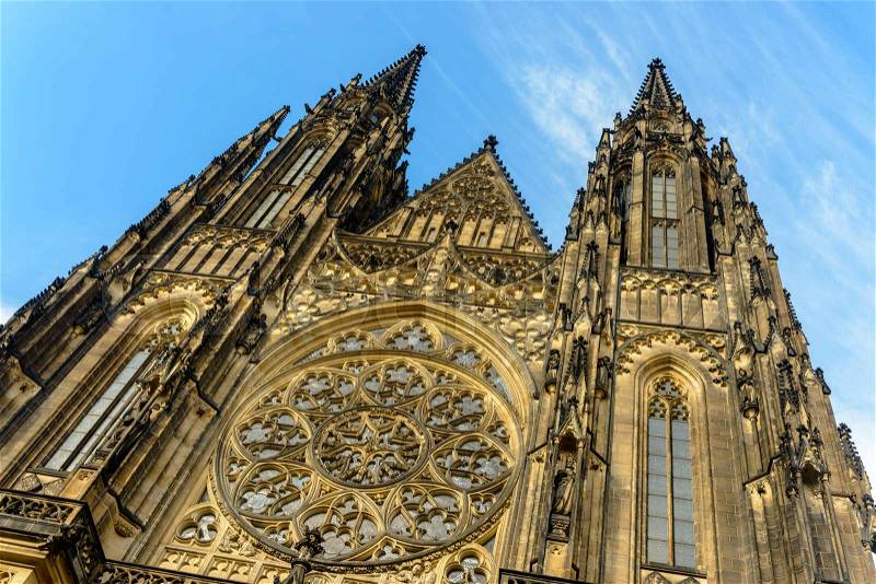 Low angle view of gothic styled cathedral with symmetrical design as sun strikes the ornate facade, stock photo
