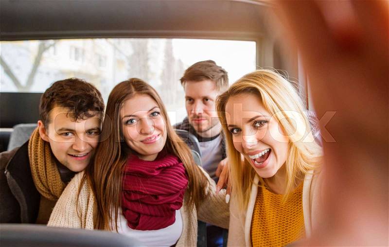 Group of beautiful young people traveling by bus, taking selfie, stock photo