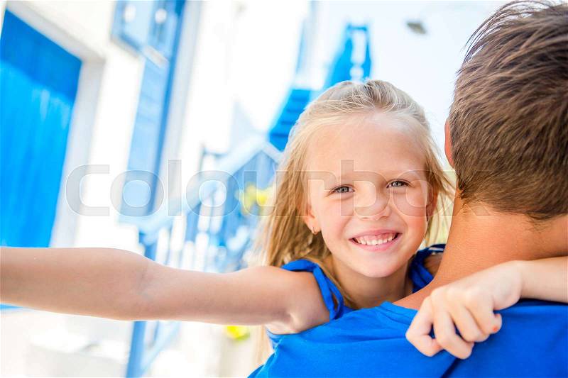 Family in Europe. Little adorable girl taking self portrait with her father in Mykonos streets during summer greek vacation, stock photo