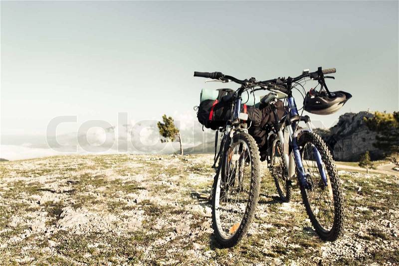 Two bikes on the precipice, sky and mountains in the background, stock photo