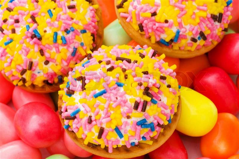 Sweet cakes and colourful gums at the background, stock photo