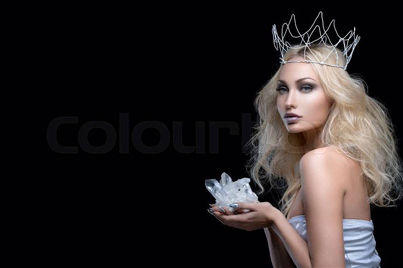 Beautiful young woman in crown holding crystal stone. Copy space, stock photo