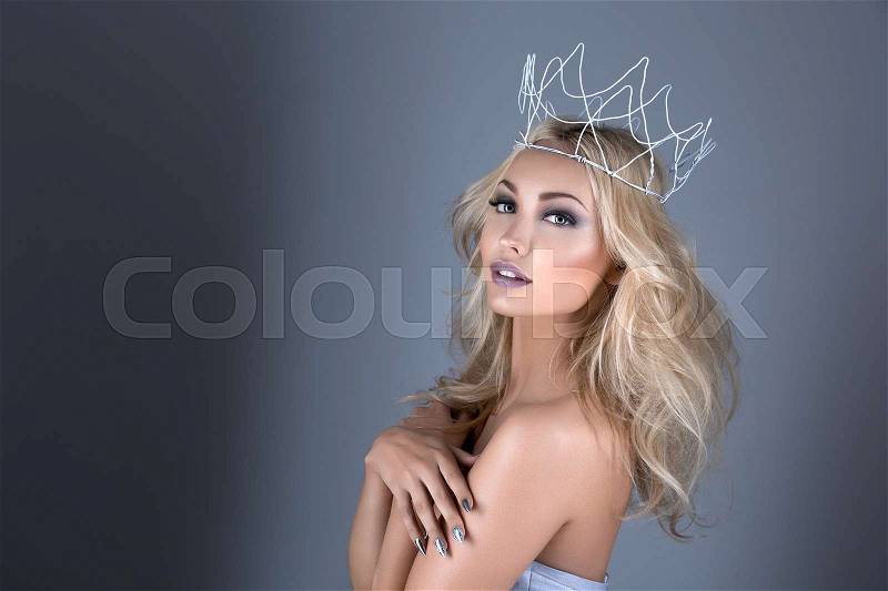 Beautiful young woman with crown. Cold tones. Copy space, stock photo