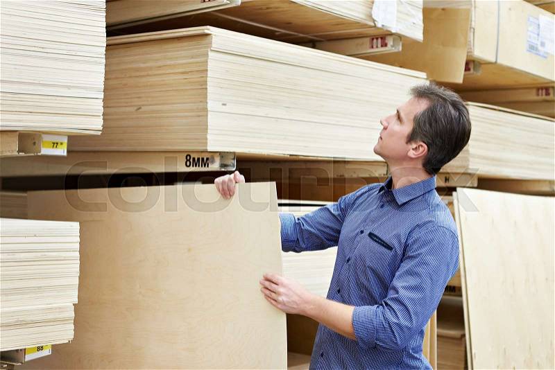 Man chooses plywood for the construction of the store, stock photo