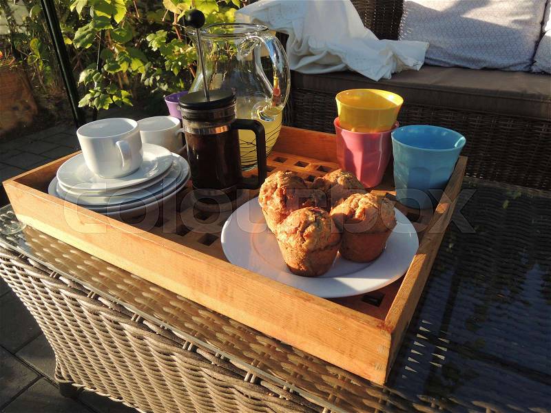 Tray with coffee and muffins ready for an afternoon break in the greenhouse, stock photo