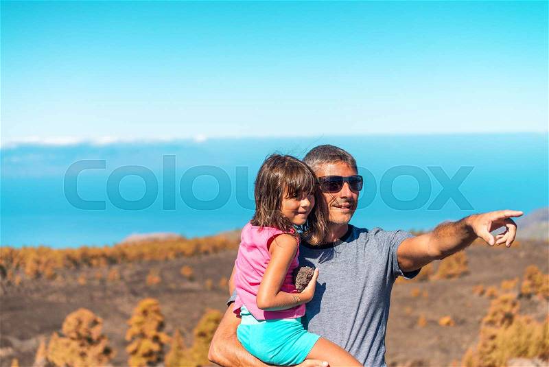 Father and daughter enjoying outdoor life with finger pointing somewhere, stock photo