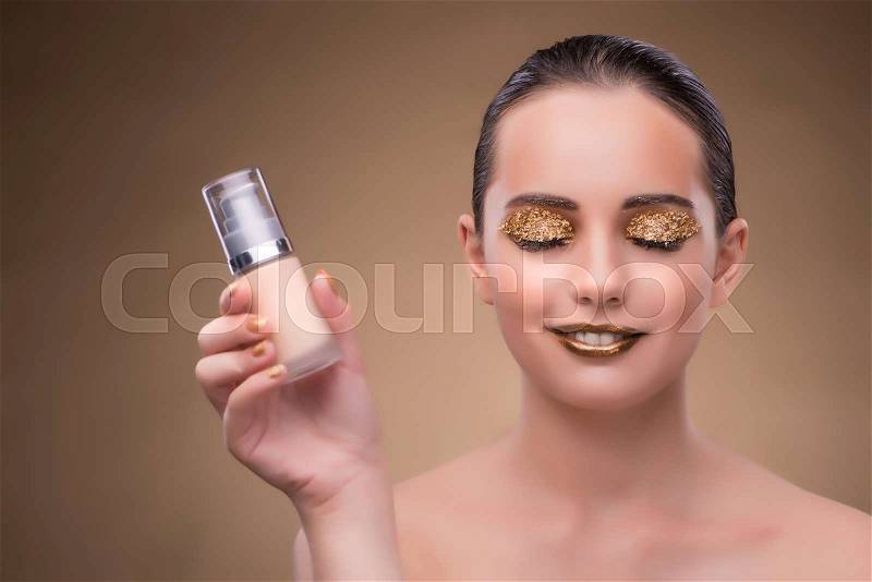 Woman with bottle of skincare cream, stock photo