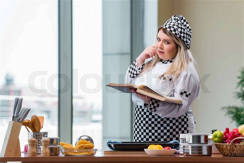 Young chef cook working in the kitchen, stock photo