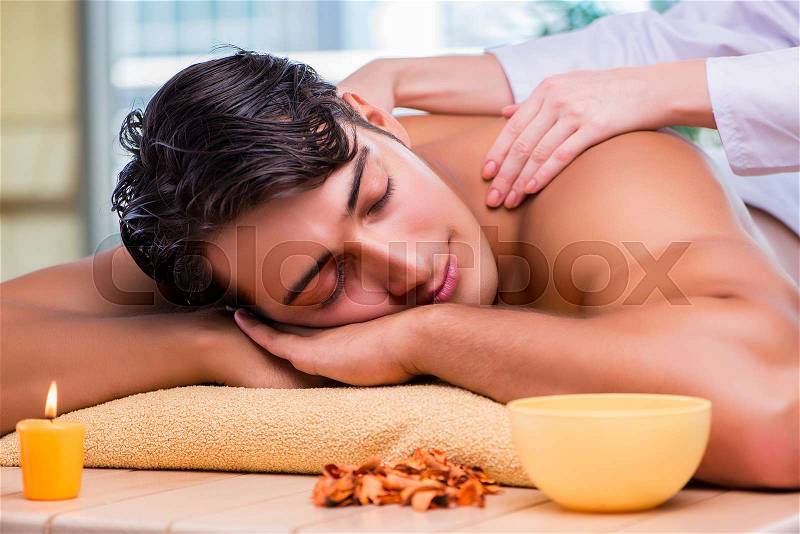 Man during massage session in spa salon, stock photo