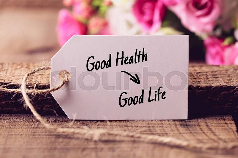 Text Good Health Results Good Life written on white label with nice blurred flower background, stock photo