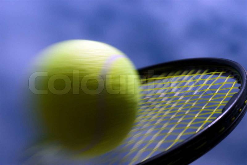 Speedy tennis ball on racket closeup and sky blue, stock photo
