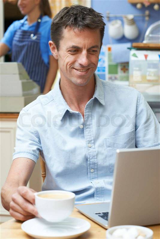 Man In Coffee Shop Using Laptop Computer, stock photo