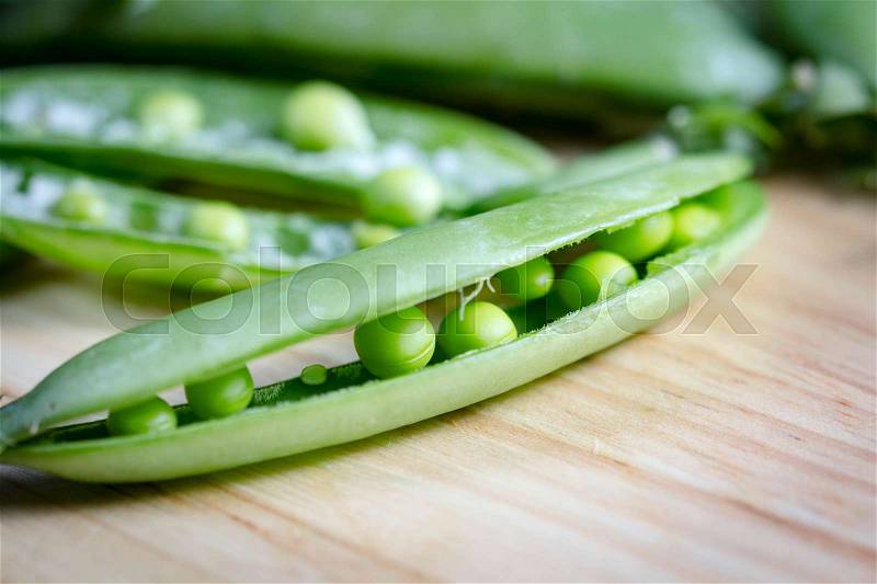 Freshly snow peas on wooden Cutting Board, stock photo