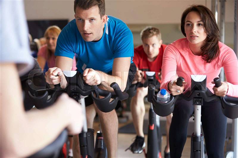 Spinning class on exercise bikes at a gym, close up, stock photo