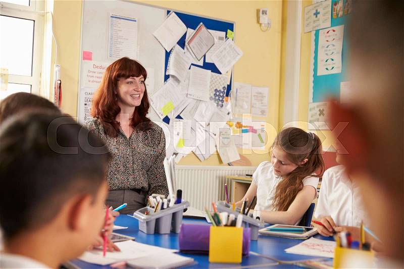 School teacher and kids work on class project, close up, stock photo