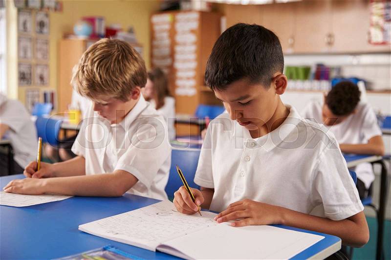 Two schoolboys working in a primary school class, close up, stock photo