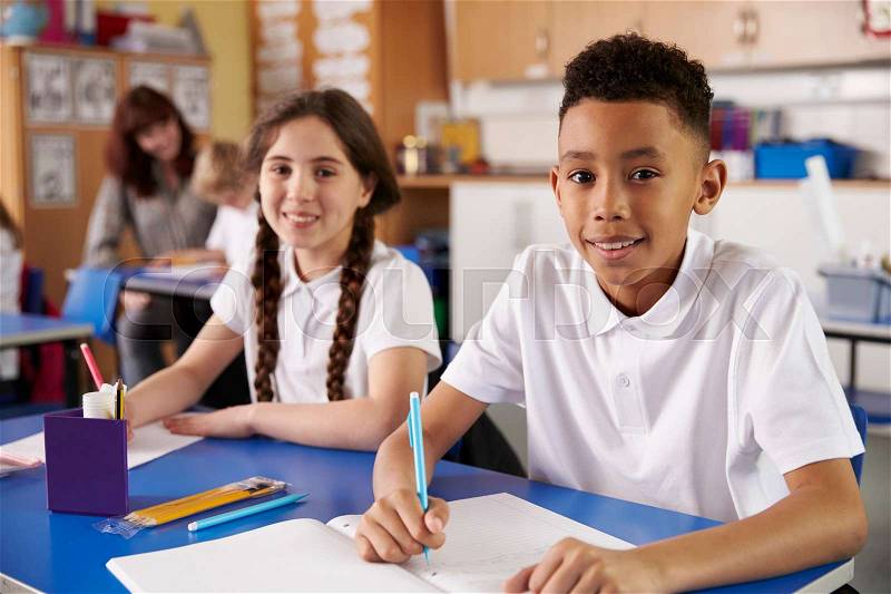 Two primary school pupils in classroom looking to camera, stock photo