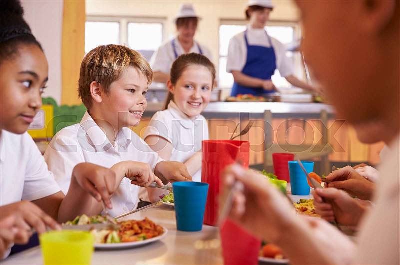 Primary school kids at a table in school cafeteria, close up, stock photo