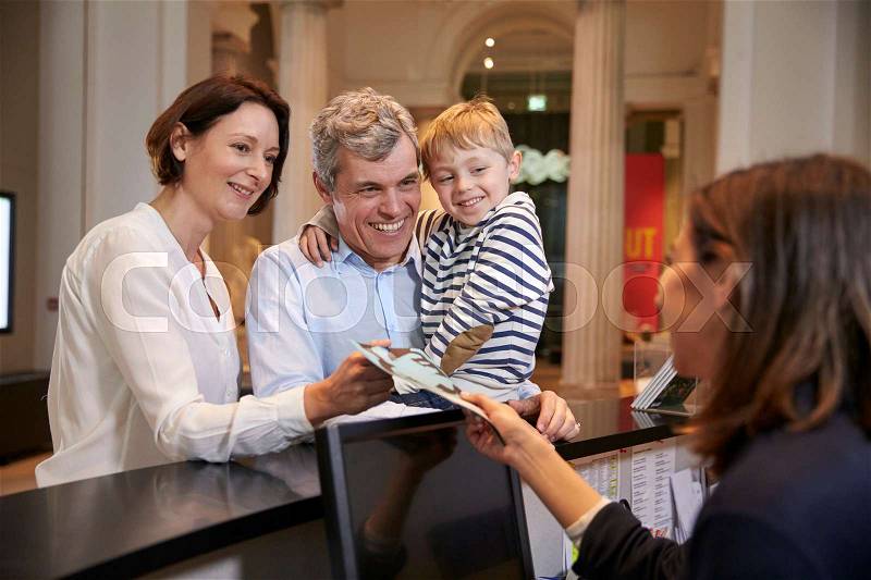 Family Buying Entry Tickets To Museum From Reception, stock photo