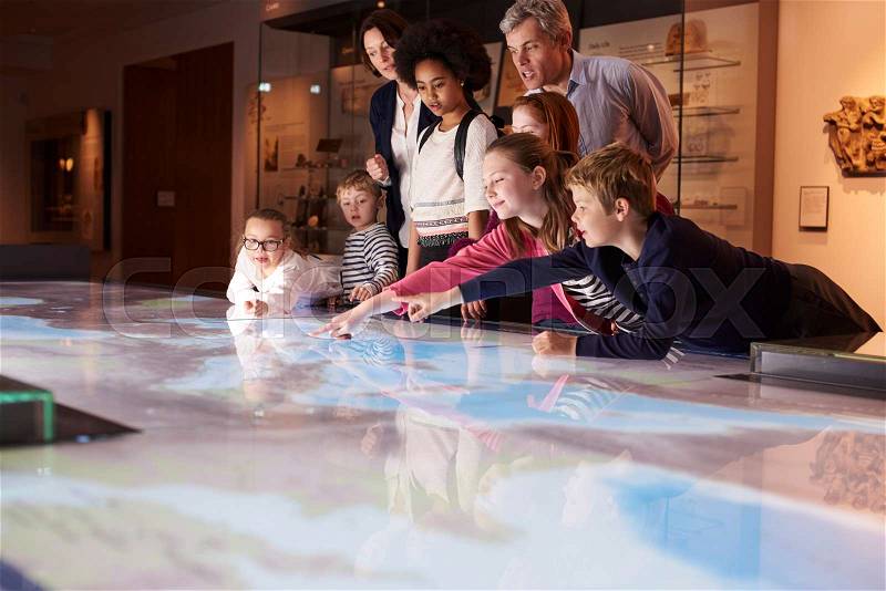 Pupils On School Field Trip To Museum Looking At Map, stock photo