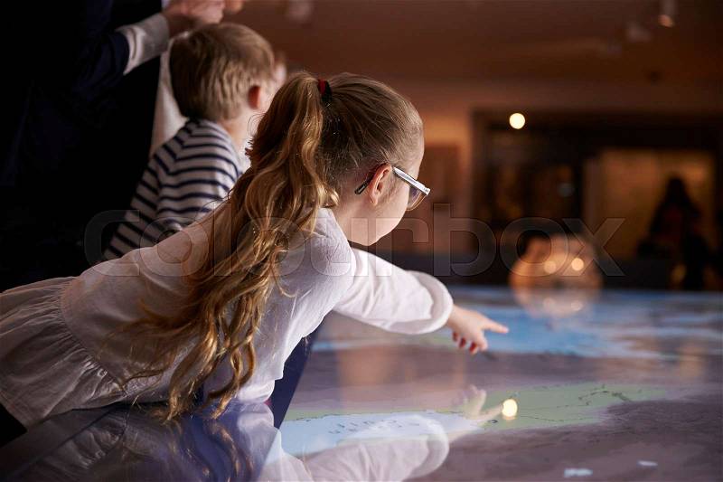Pupils On School Field Trip To Museum Looking At Map, stock photo