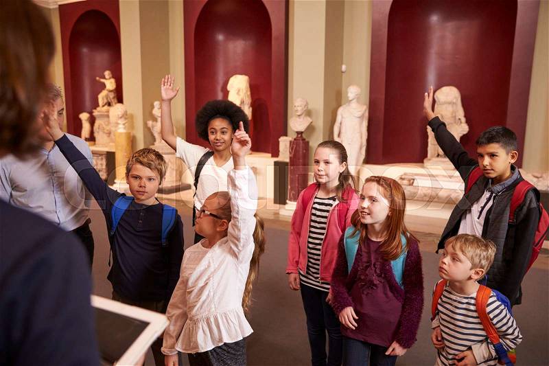 Pupils And Teacher On School Field Trip To Museum With Guide, stock photo