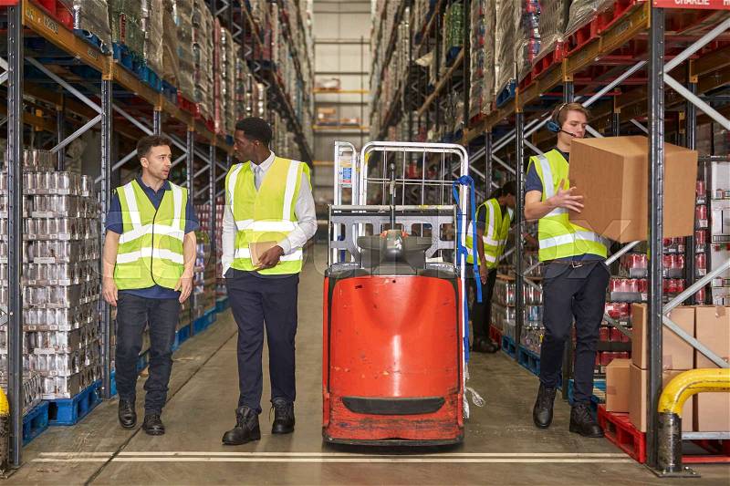 Staff at work in the aisle of a busy distribution warehouse, stock photo