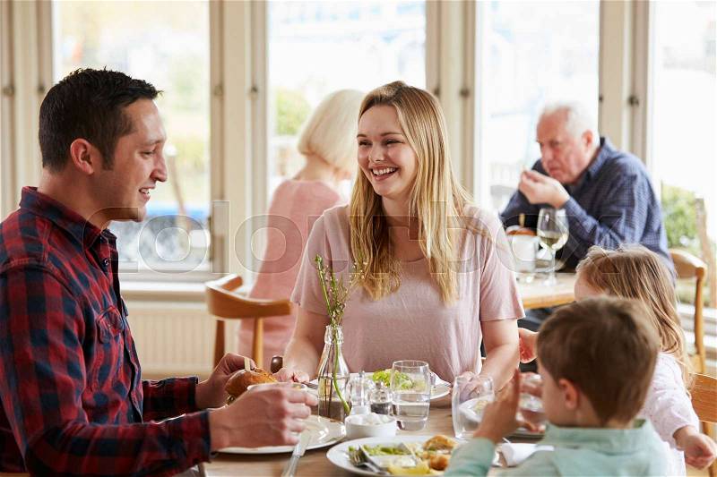 Family Enjoying Meal In Restaurant Together, stock photo