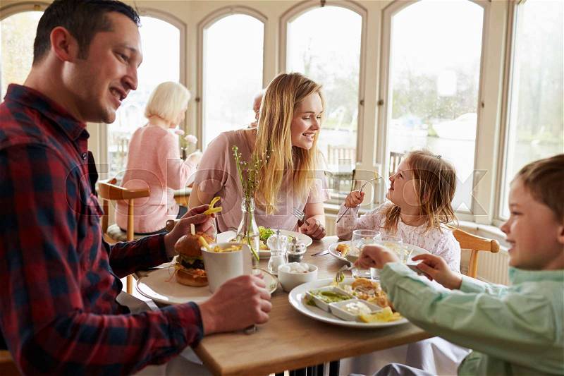 Family Enjoying Meal In Restaurant Together, stock photo