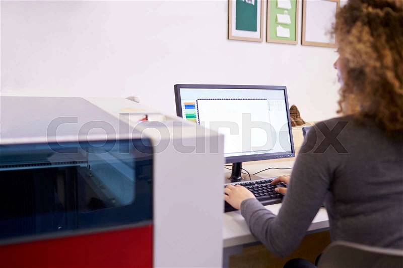 Female Designer Operating CAD System For Laser Cutter, stock photo