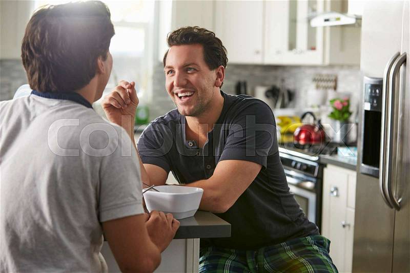 Male gay couple in their 20s talk in their kitchen, close up, stock photo