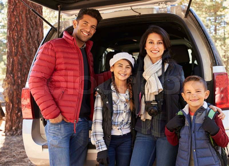 Portrait family outdoors standing at the open back of car, stock photo