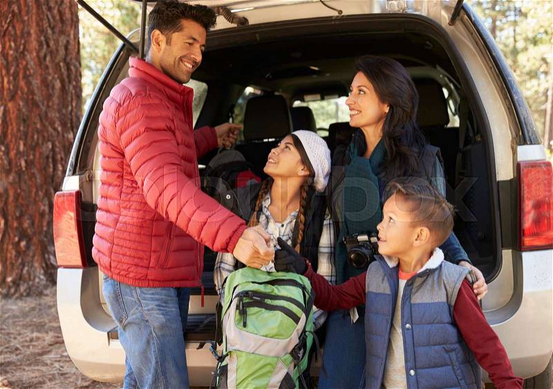 Happy family prepare for a hike at the back of their car, stock photo
