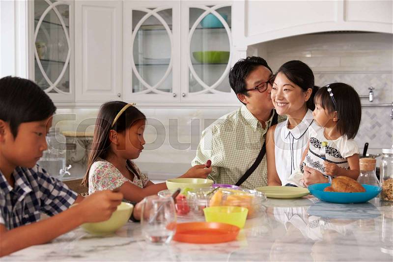 Father Leaving For Work After Family Breakfast In Kitchen, stock photo