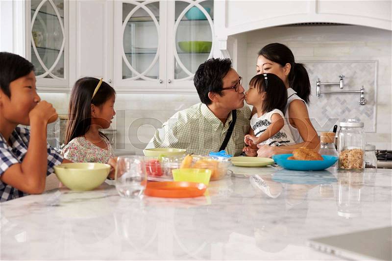 Father Leaving For Work After Family Breakfast In Kitchen, stock photo