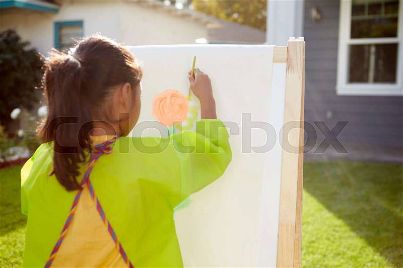 Rear View Of Girl Painting Picture In Garden, stock photo