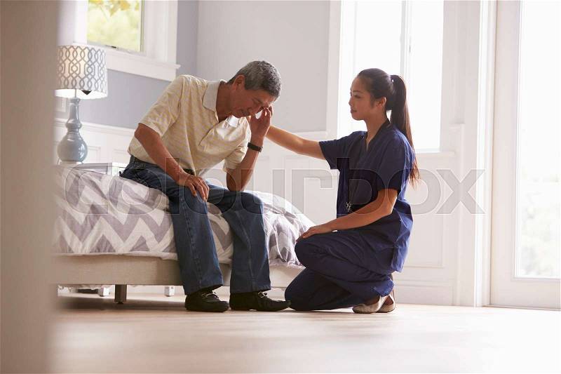 Nurse Making Home Visit To Depressed Senior Man, stock photo
