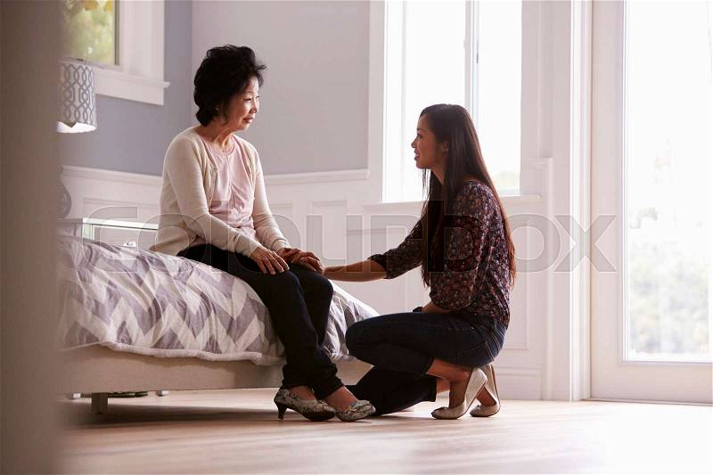 Adult Daughter Talking To Depressed Mother At Home, stock photo