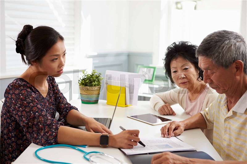 Serious Senior Couple Meeting With Doctor In Office, stock photo