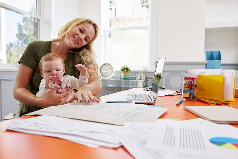 Busy Mother With Baby Running Business From Home, stock photo