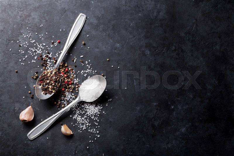 Garlic, black, white and red pepper and salt spices in spoon. Top view with copy space, stock photo
