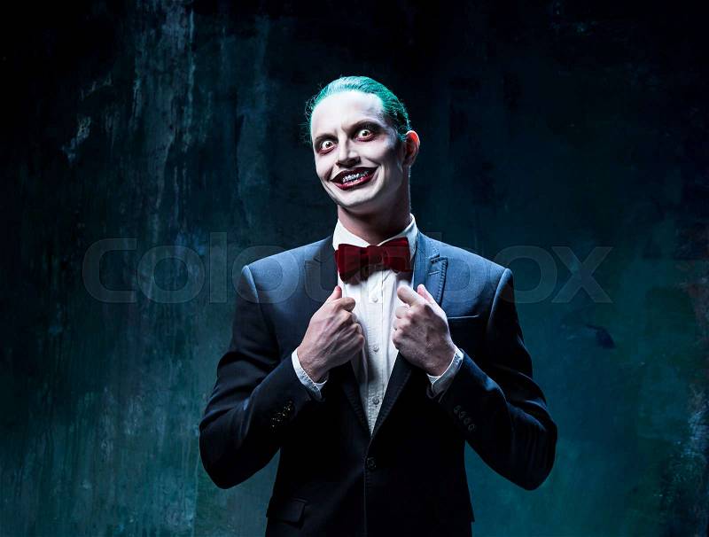 Bloody Halloween theme: The crazy joker face on black background, stock photo