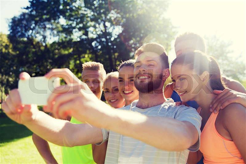 Fitness, sport, friendship, technology and healthy lifestyle concept - group of happy teenage friends taking selfie with smartphone outdoors, stock photo