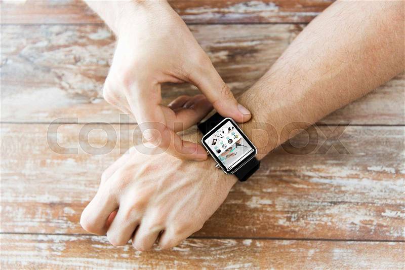 Business, modern technology, internet shopping and people concept - close up of male hands setting smart watch with online shop on screen on wooden table, stock photo