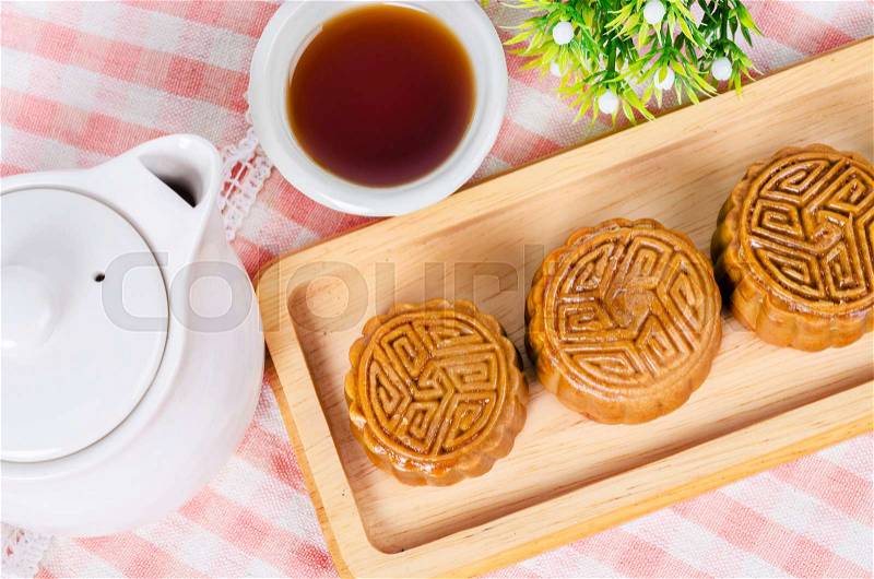 Festival moon cake and hot tea - Chinese cake on tablecloth, stock photo