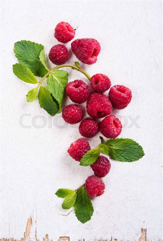 Fresh ripe raspberries on white painted board closeup, summer fruit background, stock photo