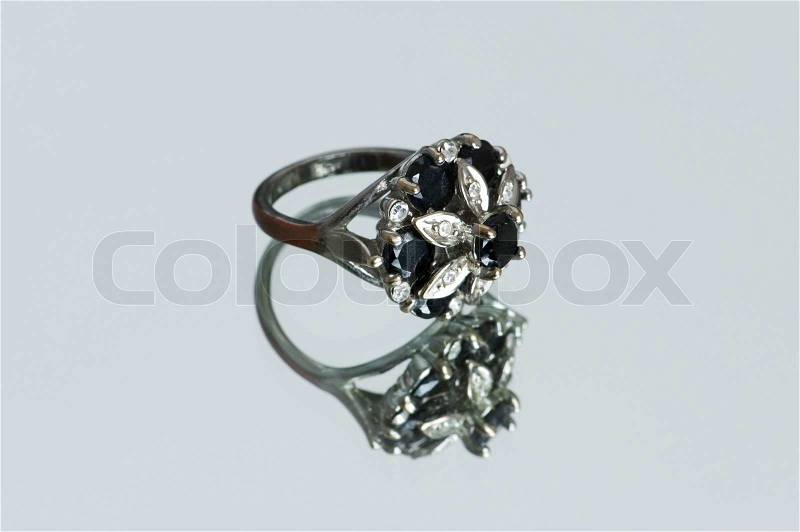 Ring with flower ornament on reflective background, stock photo